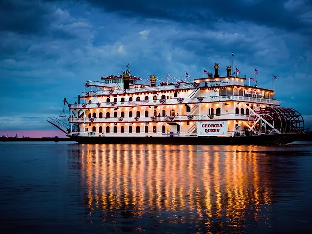 Georgia Queen riverboat glowing at dusk on the Savannah River.