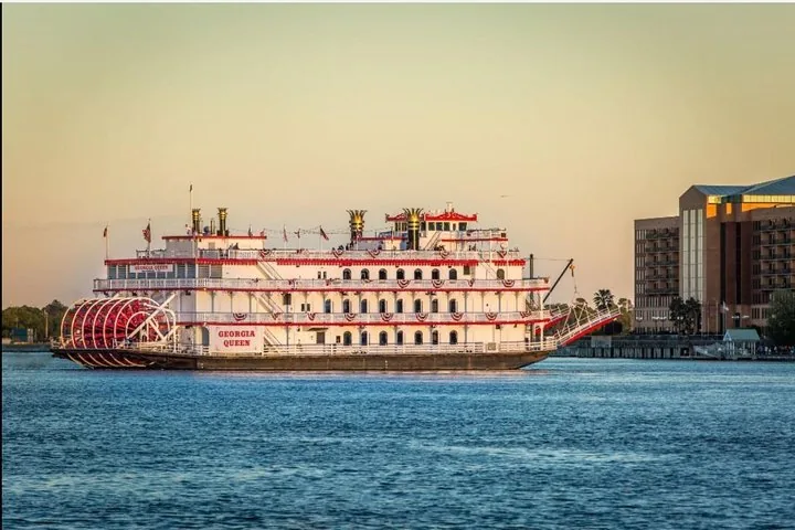 Georgia Queen riverboat cruising past city buildings along the Savannah River.